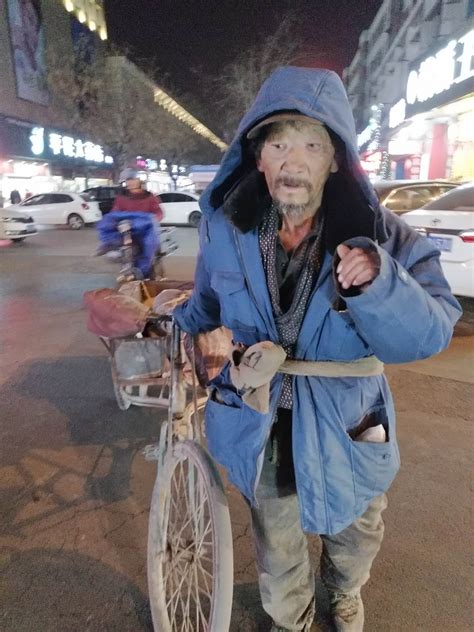 在繁华的巴黎大街的路旁坐着衣衫褴褛的老人