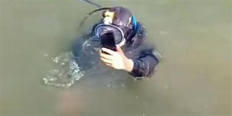 男子在水里捞手机一甩又掉下去